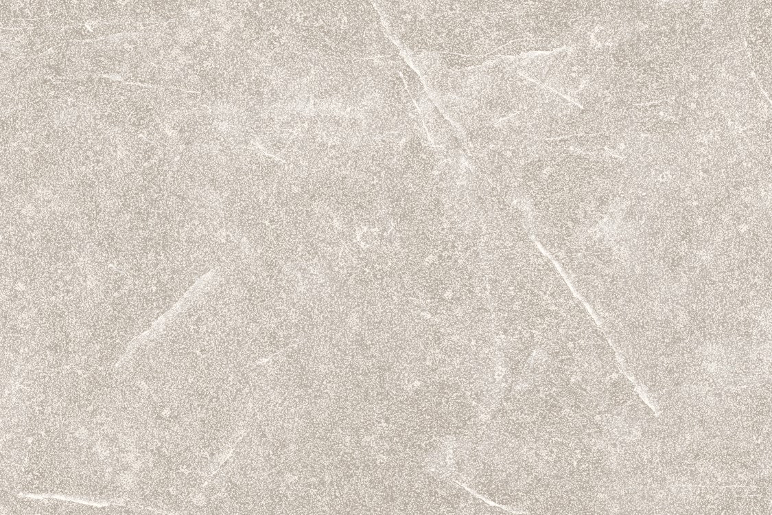 A textured light gray stone surface with faint white veins and subtle cracks, Brampton Perla Porcelain tiles offer a natural, weathered appearance—ideal for stylish outdoor porcelain tiles that blend elegance with durability.