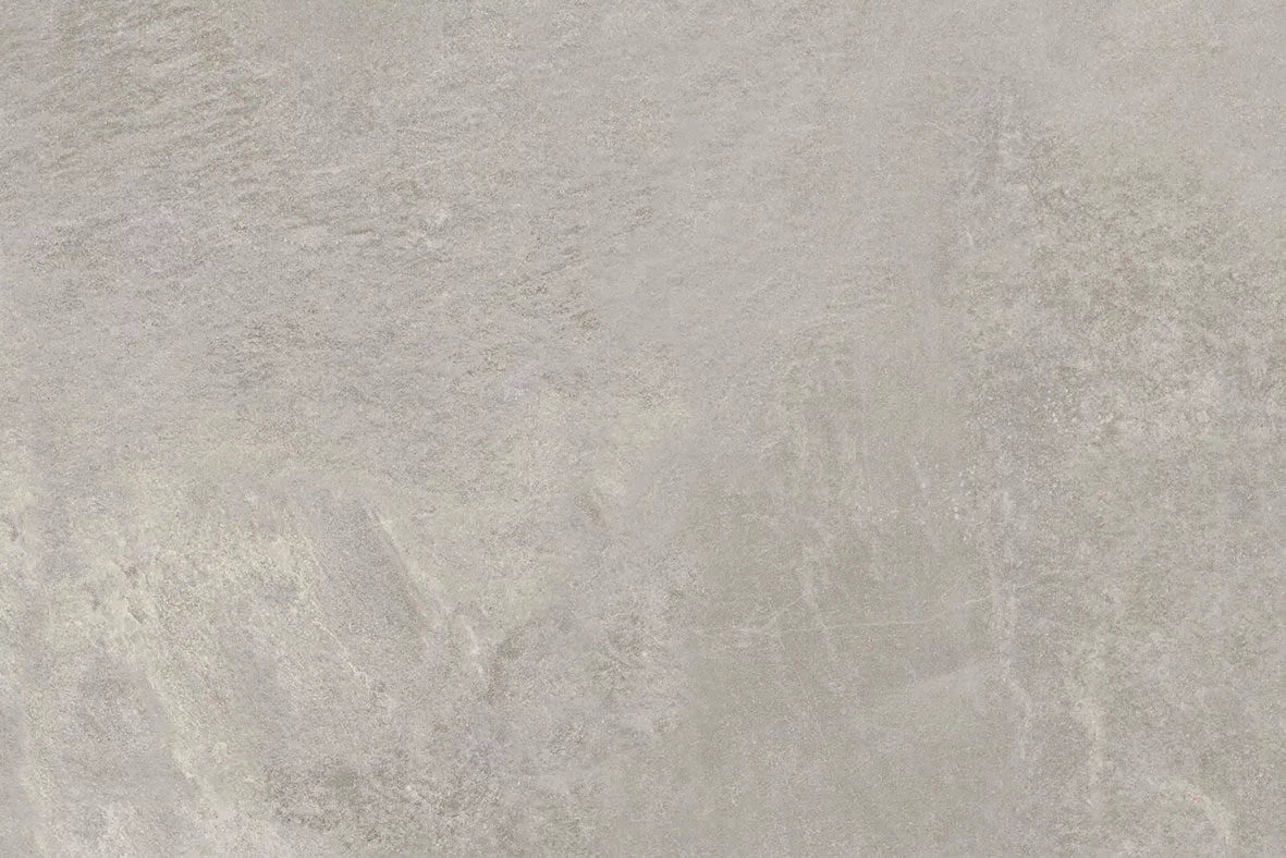 Light gray textured stone surface with subtle variations in tone and natural patterning, Fraser Grigio Porcelain Paving Slabs offer a modern look that resembles concrete or slate.