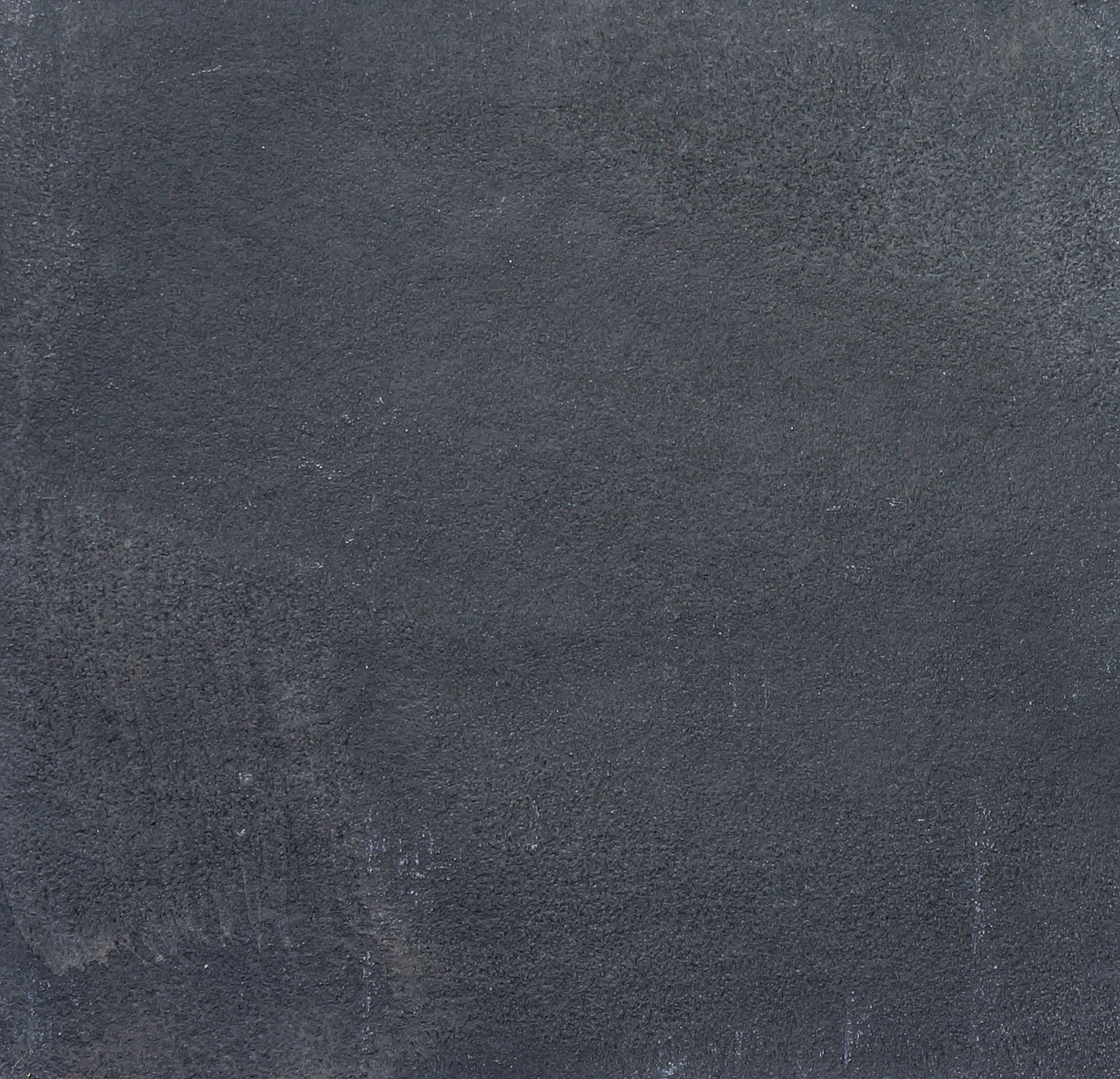 A close-up of a textured, dark gray concrete wall with subtle variations in tone and rough, uneven surface patterns, reminiscent of Kadappa Black Limestone Paving often used for stylish garden stepping stones.
