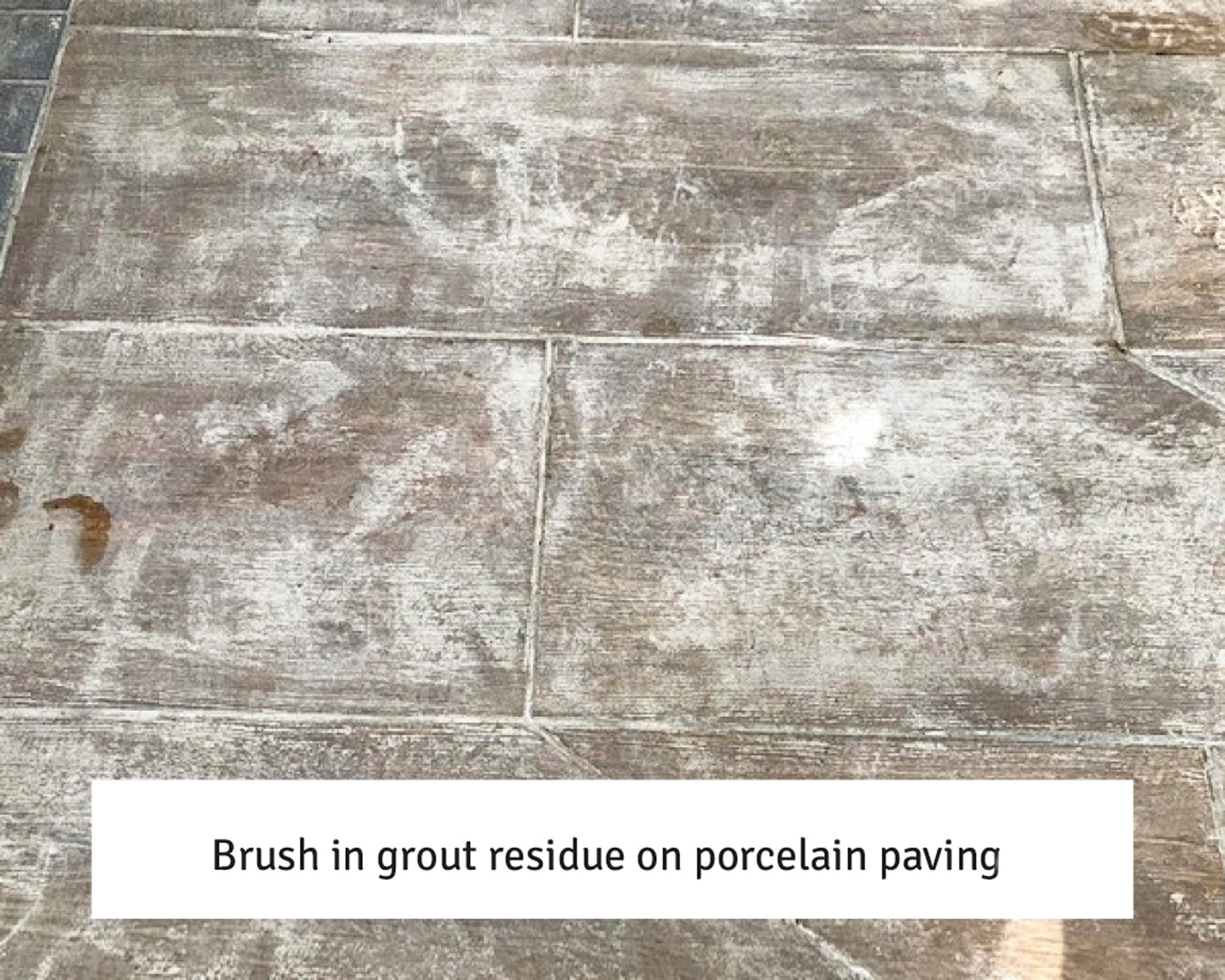 Porcelain paving slabs with white grout residue streaks and patches on the surface, showing where excess grout was left after installation. Text caption at the bottom reads: "Brush in grout residue—try a sealer remover on porcelain paving.