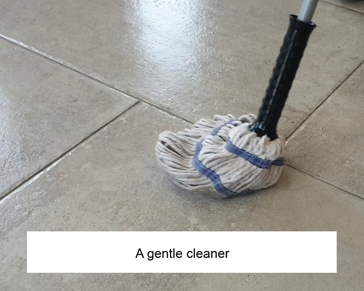 A mop with a black handle and white mop head is cleaning a shiny tiled floor. The image includes the caption, "A gentle cleaner for delicate surfaces.