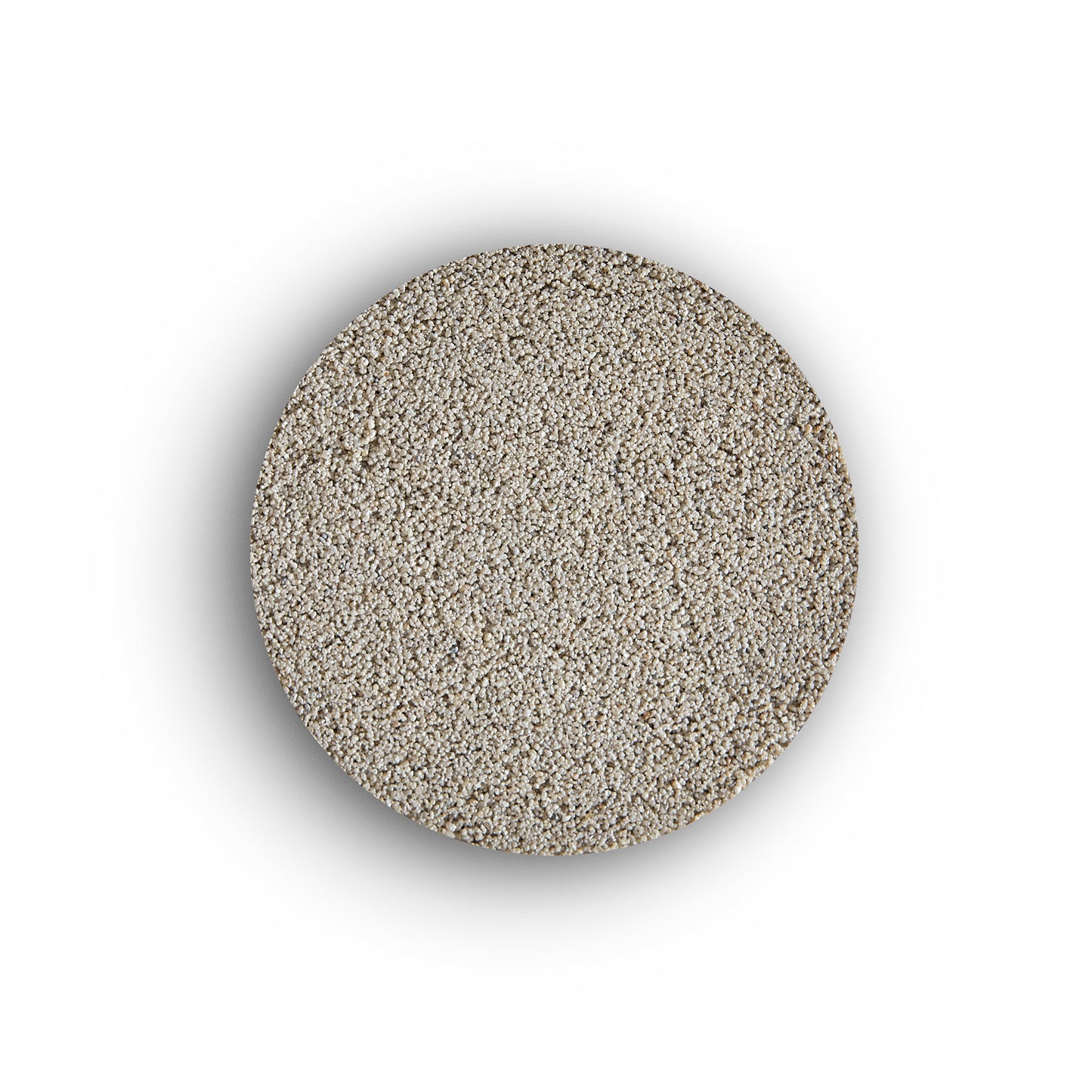 A round, flat pile of fine, light-colored sand—resembling external tile grout—is centered on a white background, casting a subtle shadow around its edges.