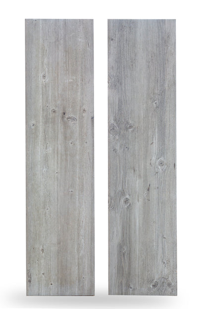 Two rectangular wood look porcelain tiles with a light gray, weathered finish and visible wood grain patterns, knots, and subtle texture, standing upright against a white background.