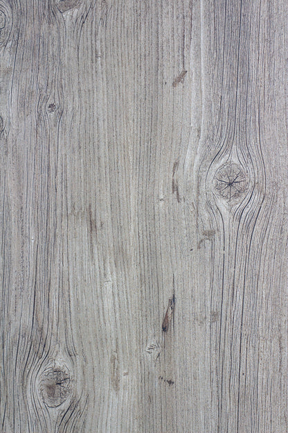 Close-up of a wooden surface featuring a light brown color with visible grain patterns and knots, similar to the texture found in wood look porcelain tile. The natural lines and imperfections add realistic depth and character.