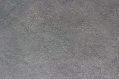 Rough, gray stone surface with subtle texture and natural variegation; appears slightly uneven and has a muted, matte finish—ideal as a slip-resistant tile for outdoor porcelain tile applications.