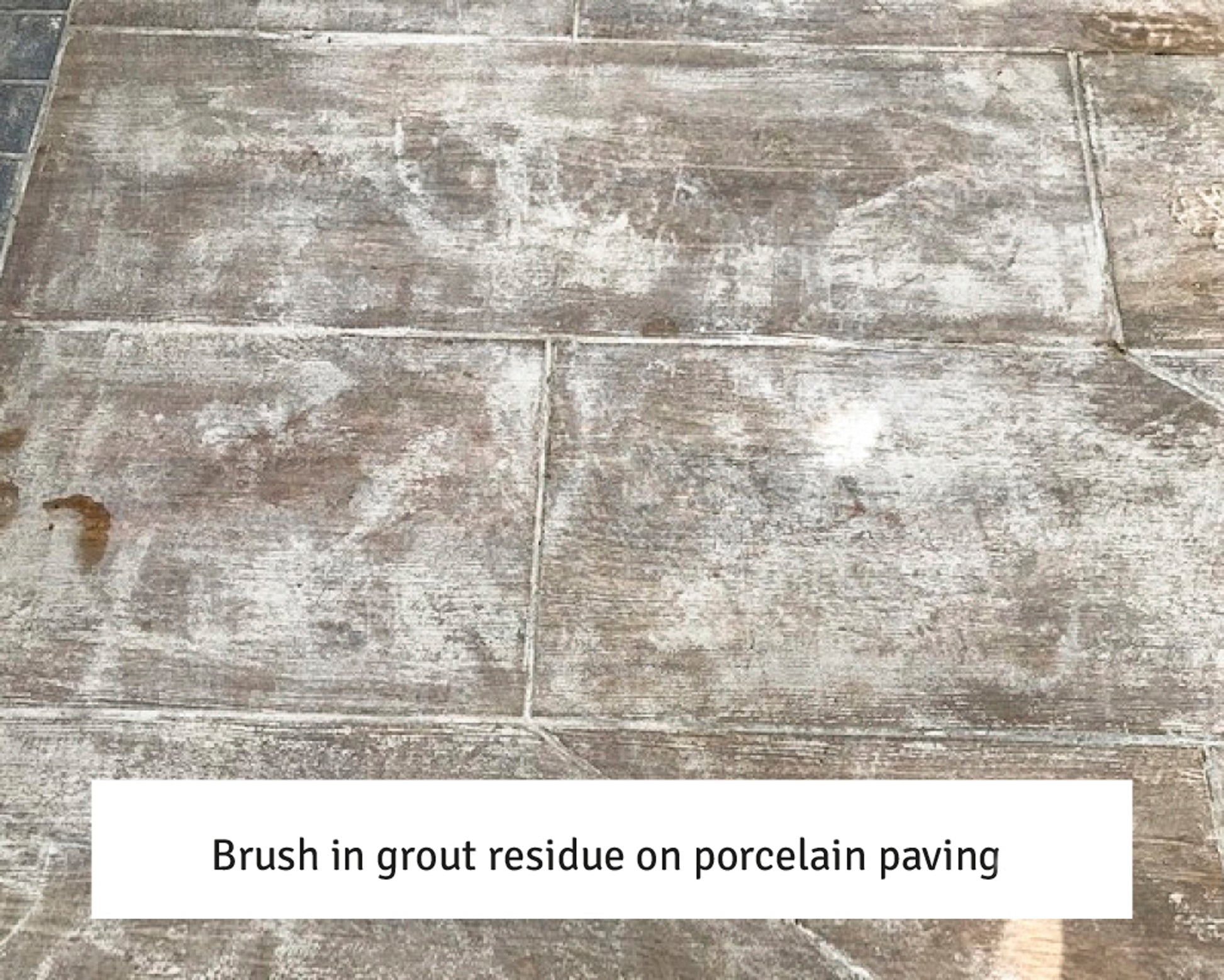 Porcelain paving slabs with white grout residue streaks and patches on the surface, showing where excess grout was left after installation. Text caption at the bottom reads: "Brush in grout residue—try a sealer remover on porcelain paving.