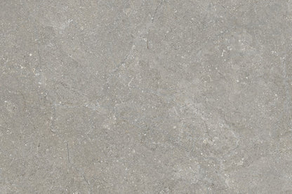Close-up of a gray porcelain tile surface with subtle variations in tone, faint white veining, and a slightly rough texture, resembling natural concrete or polished cement.
