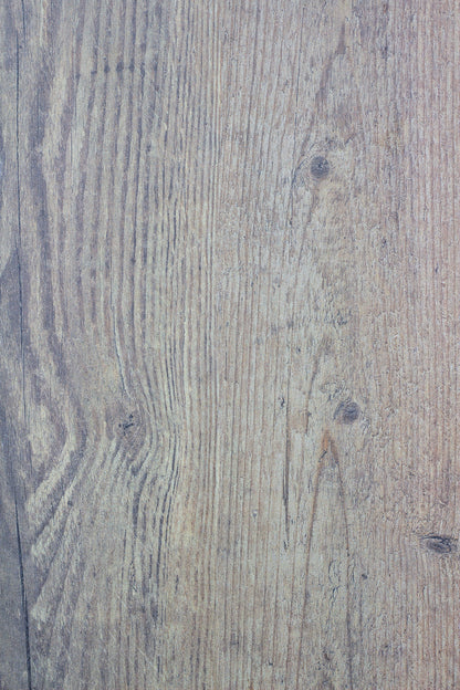 Close-up of a light brown wooden surface with visible grain patterns, knots, and subtle texture variations, capturing a natural wood appearance running vertically across the image.